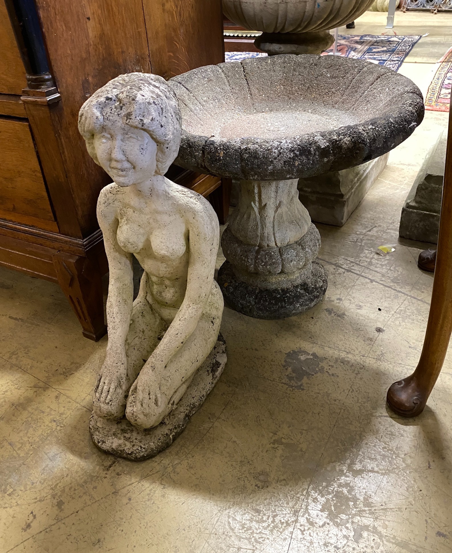 A circular reconstituted stone bird bath, diameter 48cm, height 42cm, together with a reconstituted stone kneeling figure